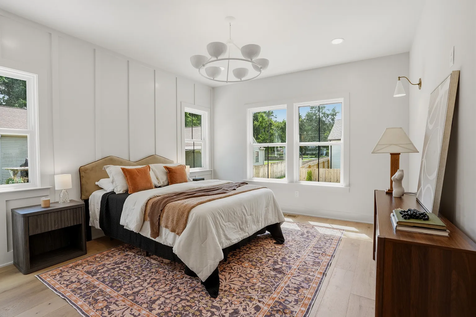 Primary bedroom with linen bedding and oak floors